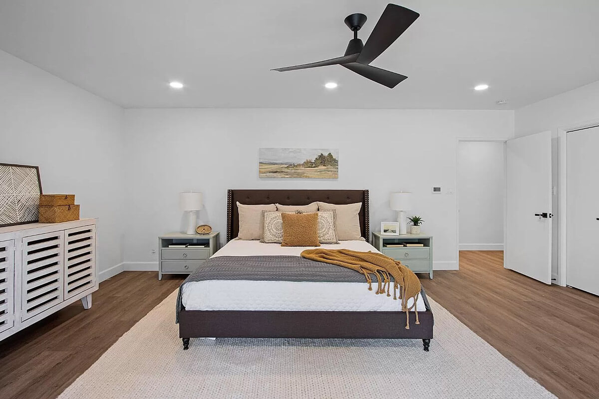 A cozy bedroom with a bed and a ceiling fan, providing comfort and relaxation.