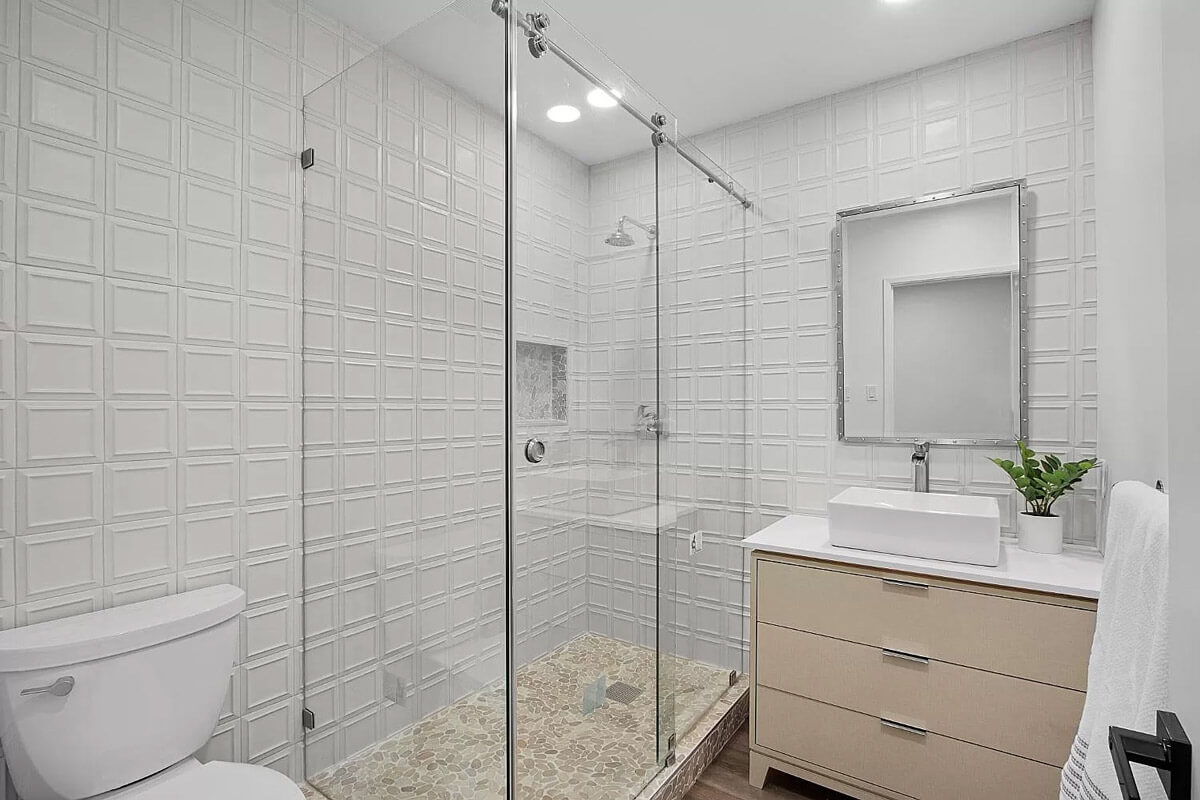 A modern bathroom with a glass shower door and a toilet.