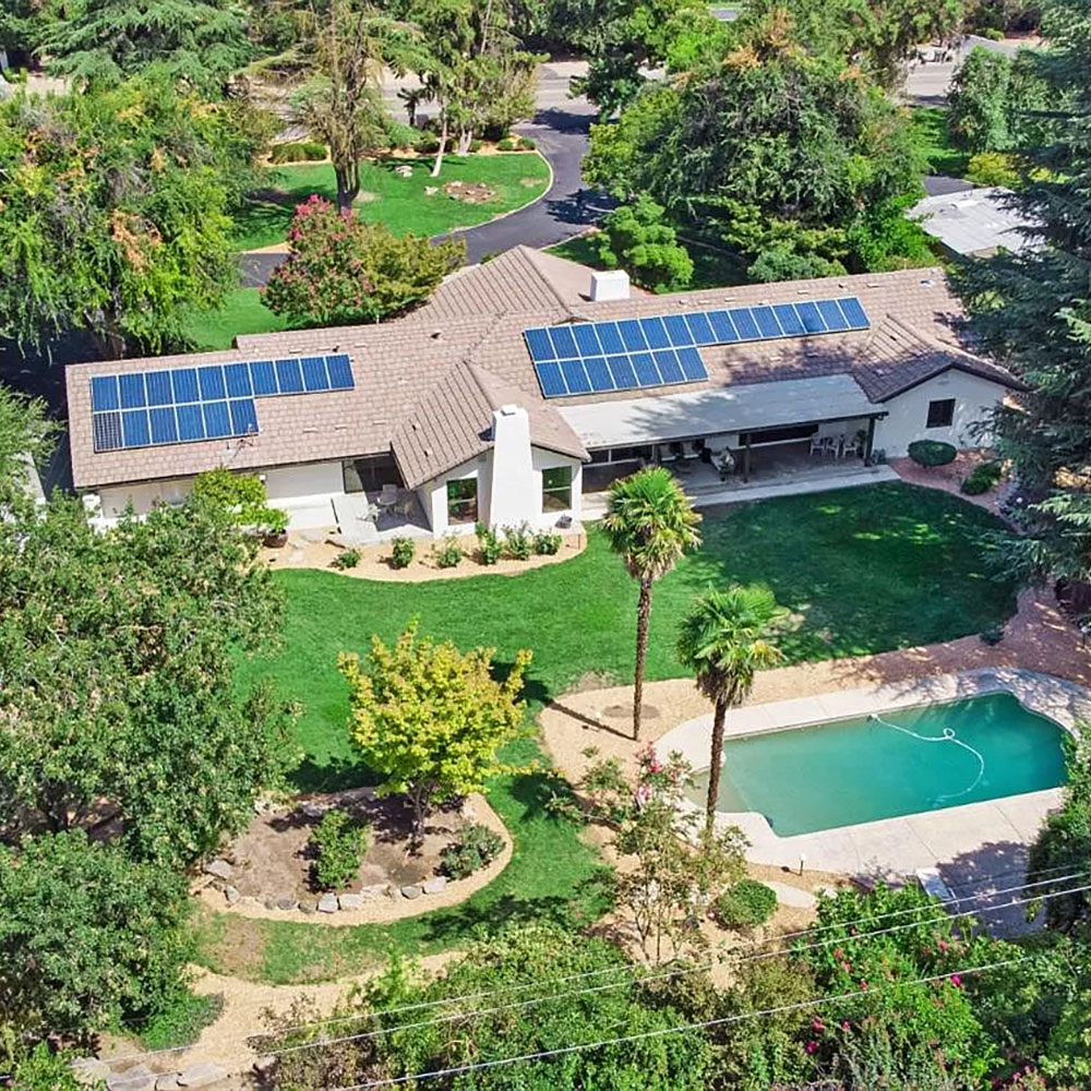 Aerial view of a home with solar panels, harnessing renewable energy for sustainable living.