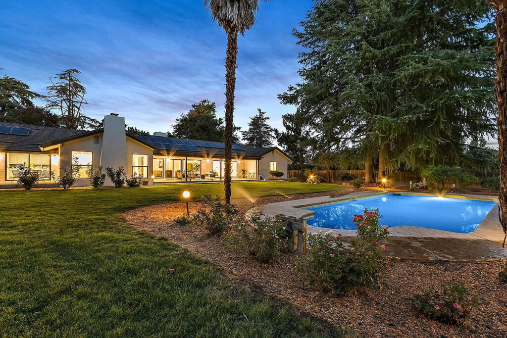 A serene home with a sparkling pool and well-maintained lawn